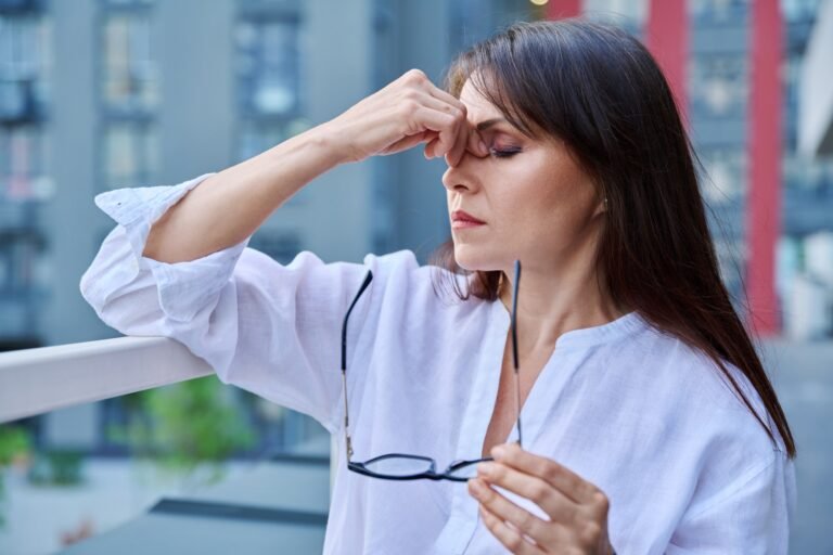 Mature woman experiencing stress headache, health problems, outdoor