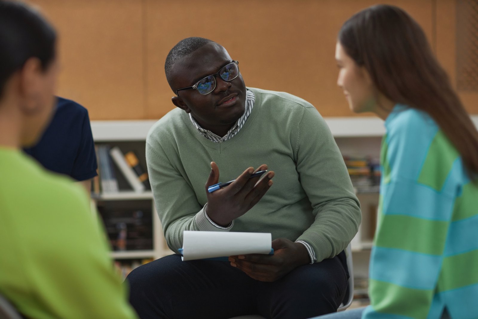 Black man as mental health therapist talking to teenage girl